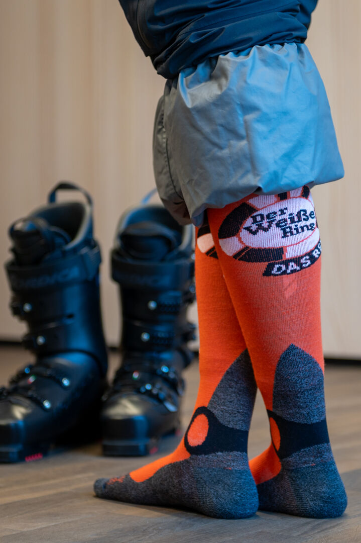 Orange Skisocken mit Der Weiße Ring das Rennen Logo an der Wade